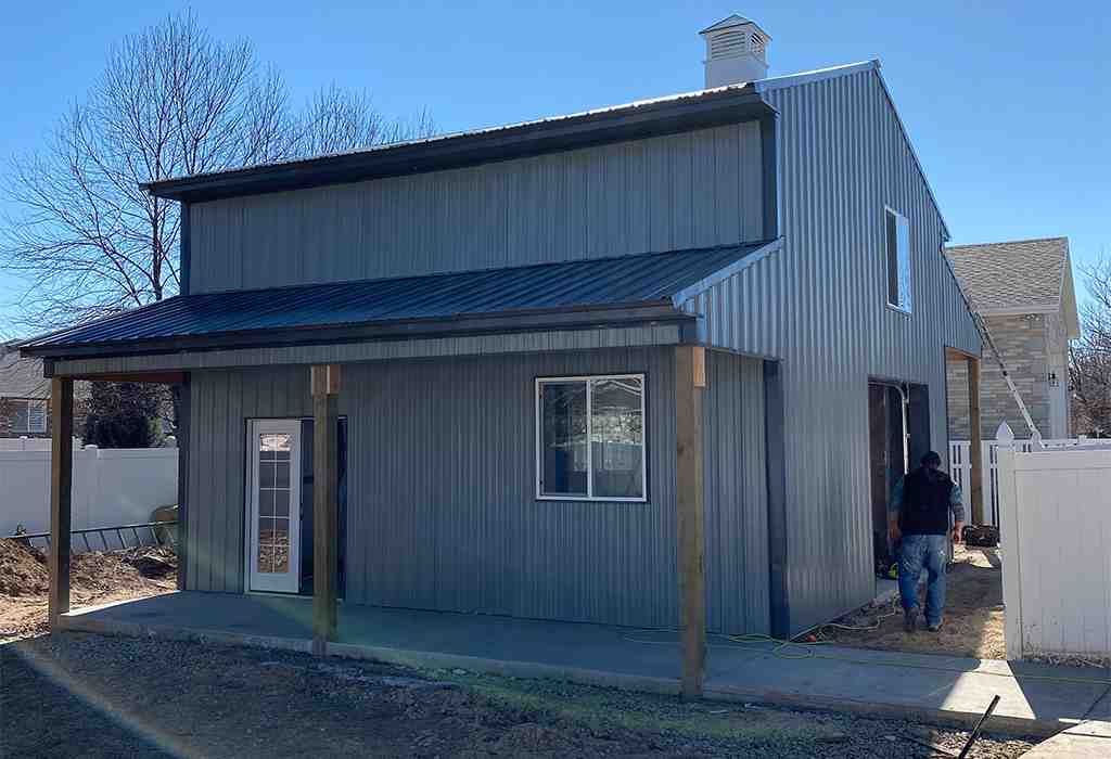 A metal pole barn with a lean-to addition, perfect for additional wood storage and workspace.