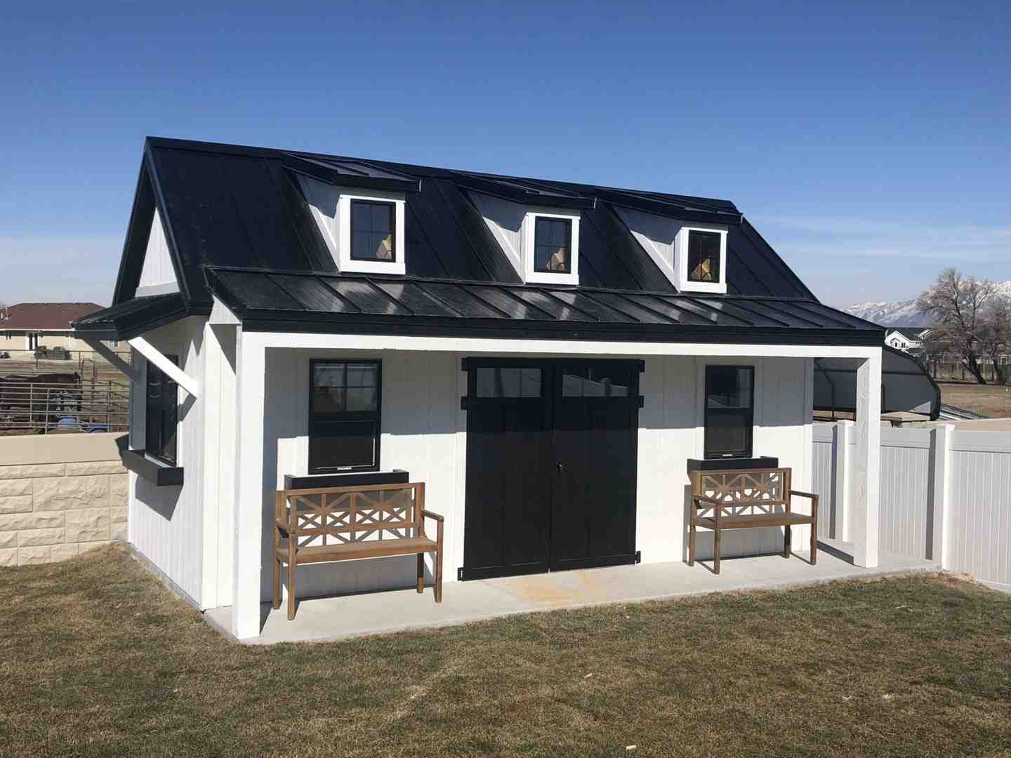 Sleek black and white orchard shed with dormer windows – modern orchard shed painting with flat roof dormers.