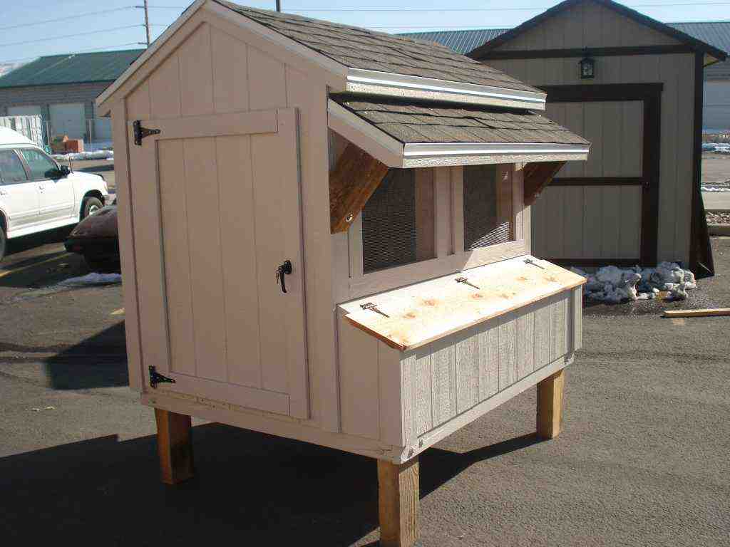 A cream-colored chicken coop with a sloped roof, mesh window, and raised platform.