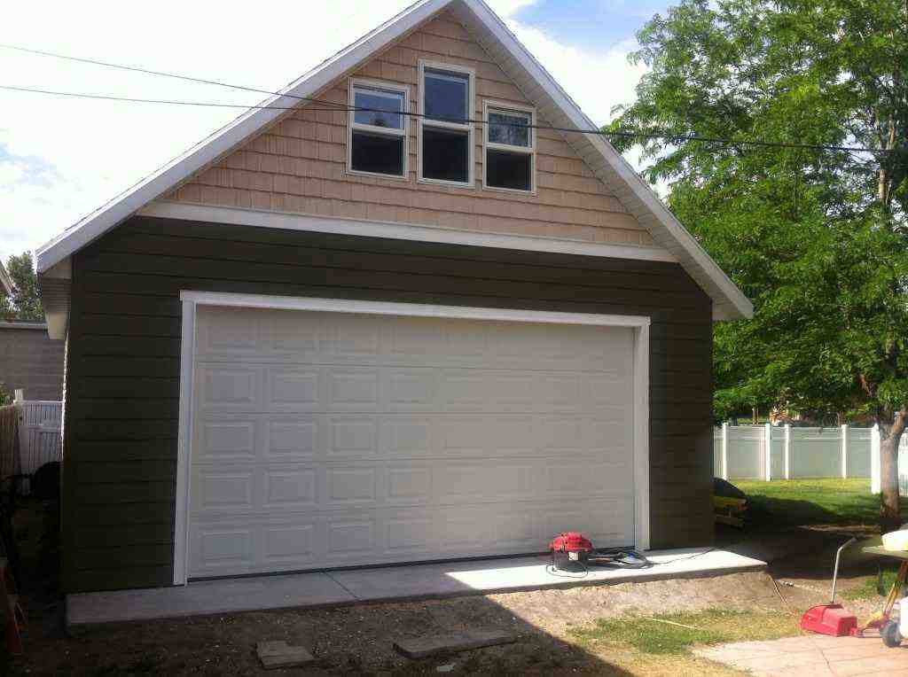A beautifully built green detached garage with a loft, showcasing Wright's Shed Co.'s craftsmanship.