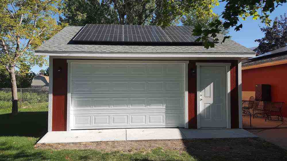A custom garage featuring solar panels installed on the roof, built by Wright's Shed Co.