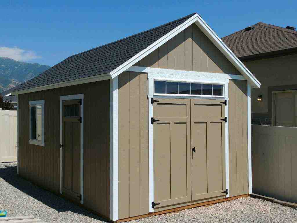 A well-constructed orchard shed with a T-door and a sloped roof, placed on a gravel base.