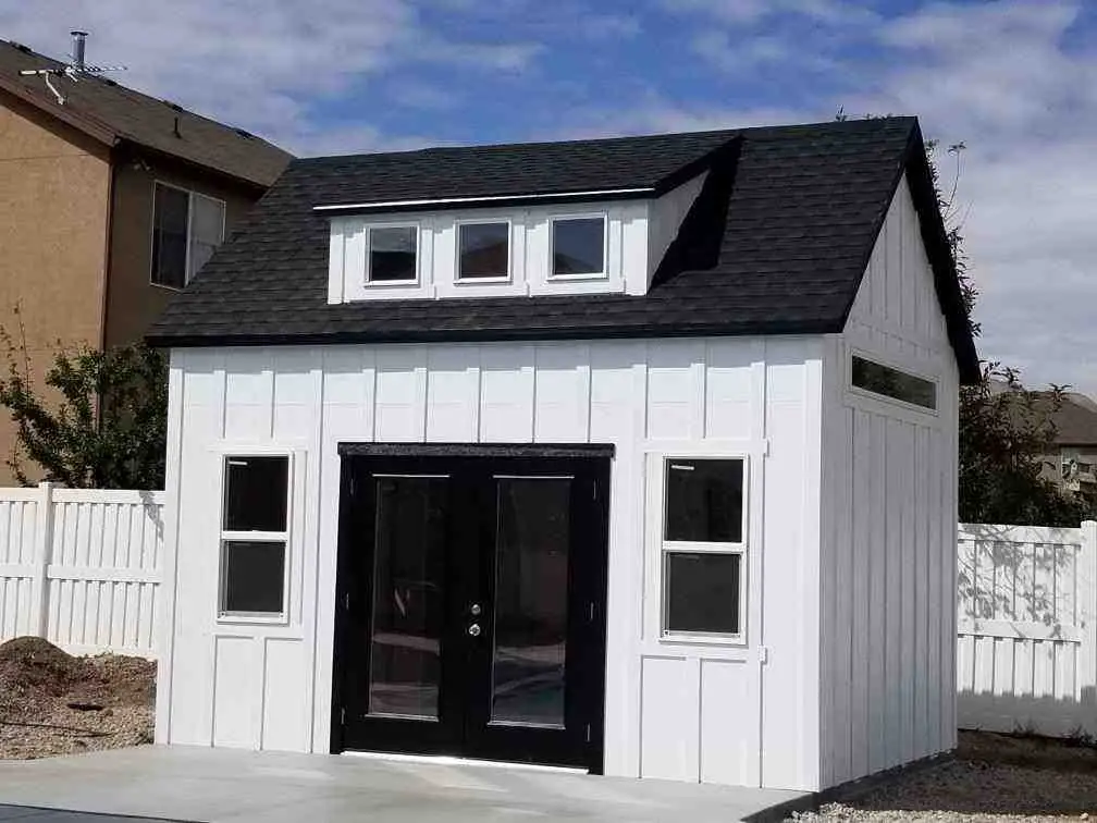 Modern Orchard Style Cool Shed Designs White backyard studio shed with black trim and full glass doors showcasing cool shed designs for stylish and functional outdoor spaces.