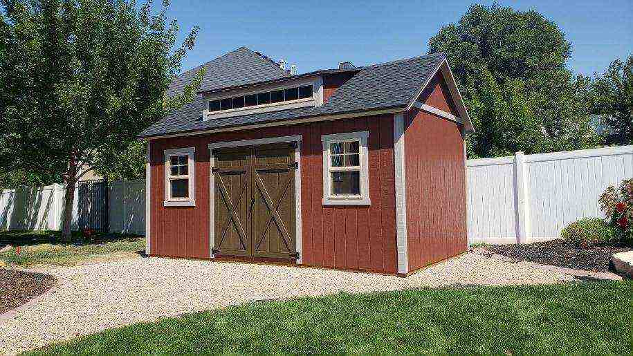 Freshly painted red backyard shed with barn-style double doors – backyard shed painting focus.