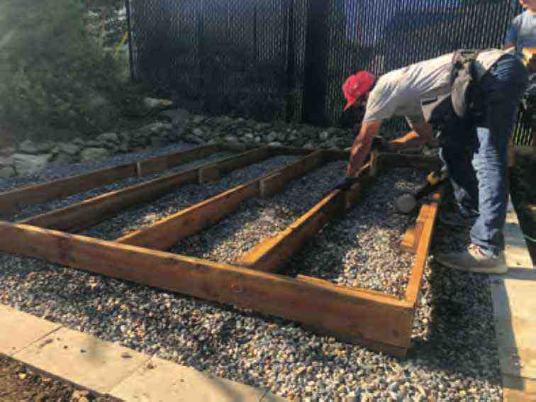 Laying the gravel foundation and wooden frame for a storage shed, a crucial step in building your own storage shed.