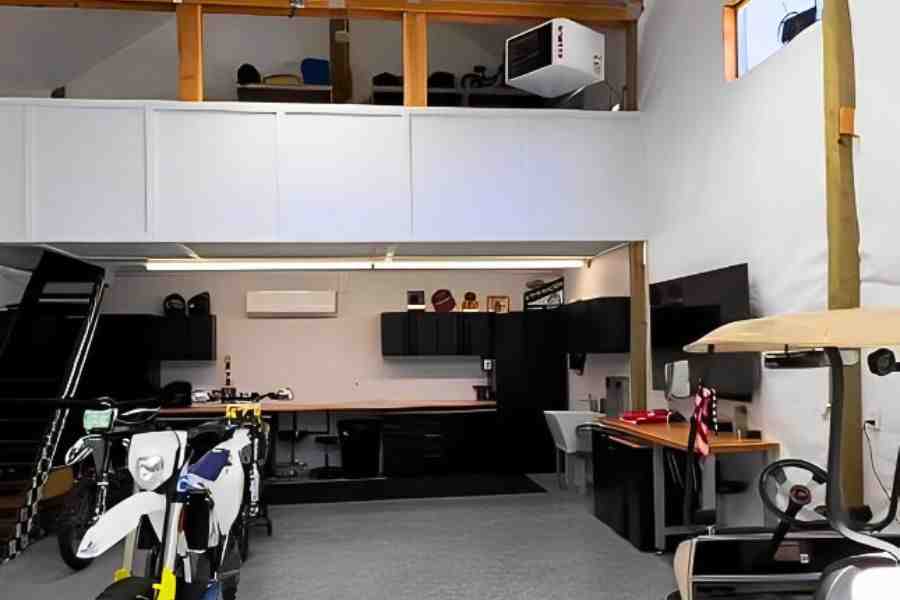 Interior view of a custom pole barn featuring a loft, work area, and garage space for bikes and a golf cart.