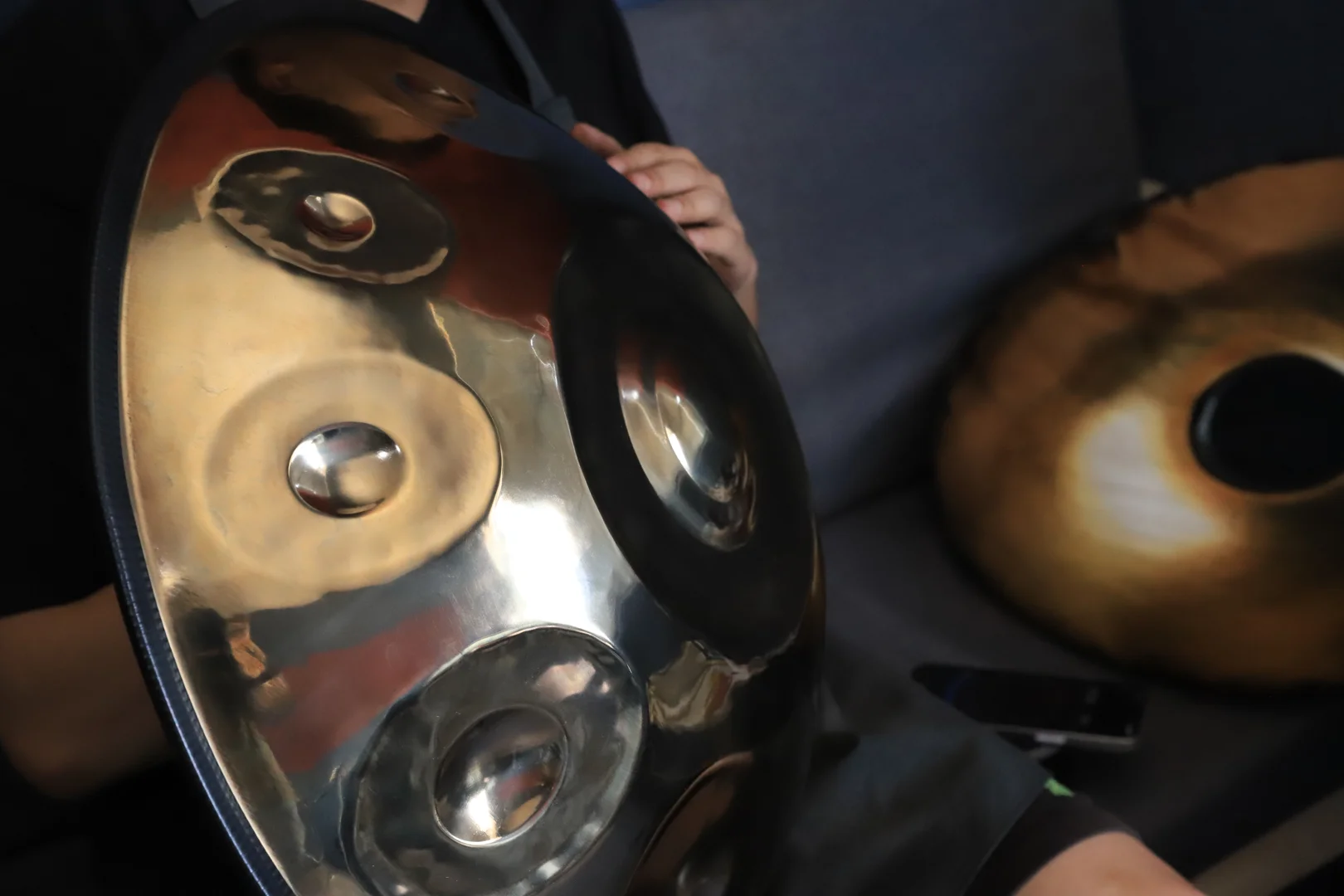 Player testing different handpan scales in a calm studio space Player testing different handpan scales in a calm studio space