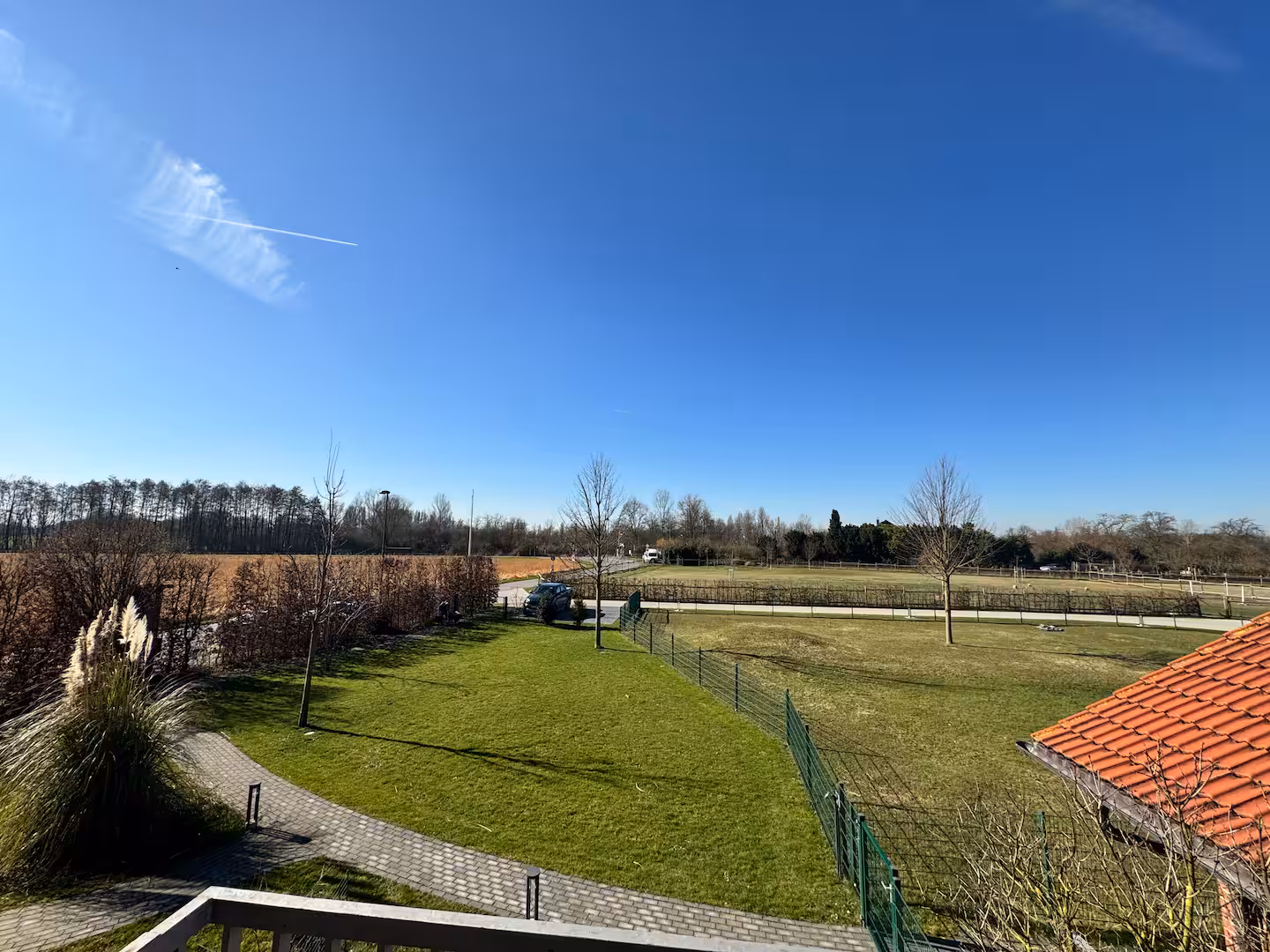 Ausblick vom balkon auf gruene weiden und alpaka koppel