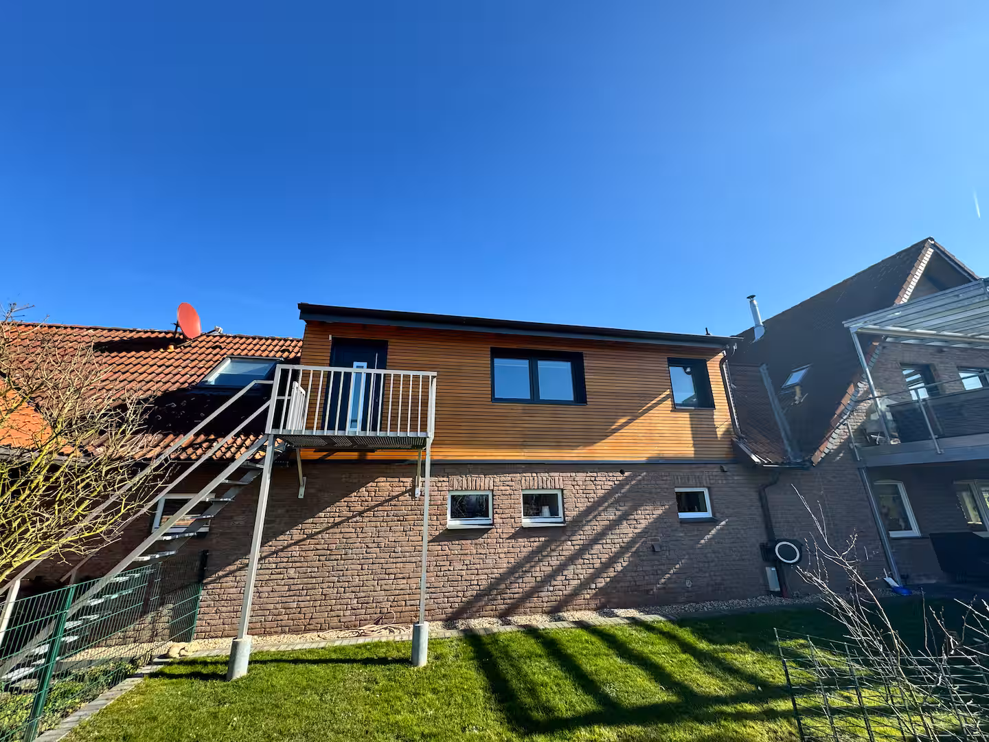 Ferienwohnung alpakahof aussenansicht mit holzfassade und garten