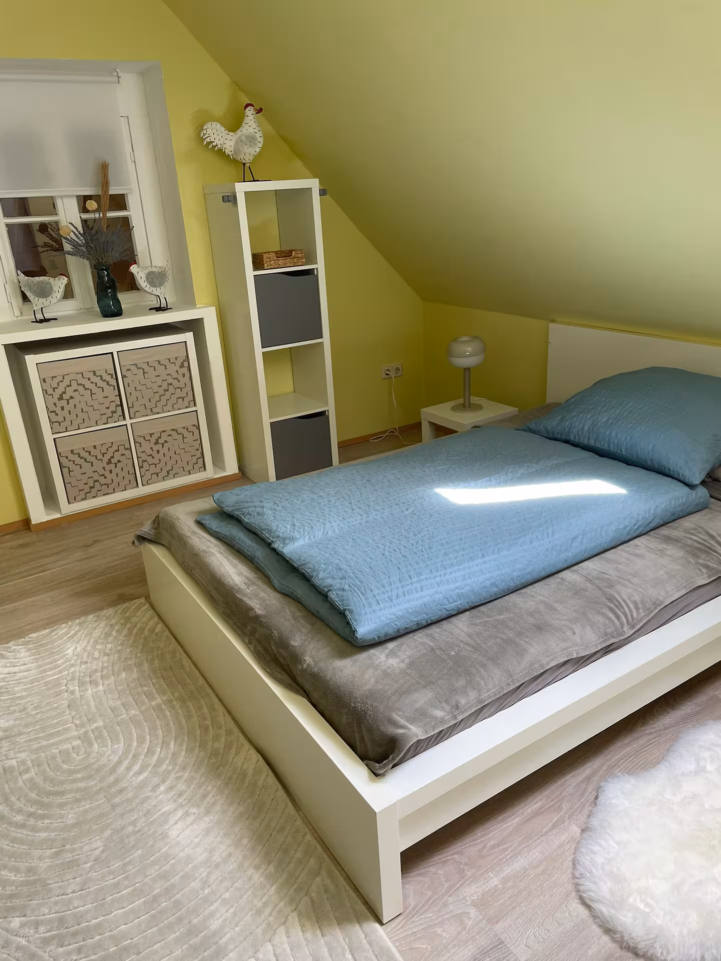 Helles schlafzimmer mit doppelbett und gruener wand
