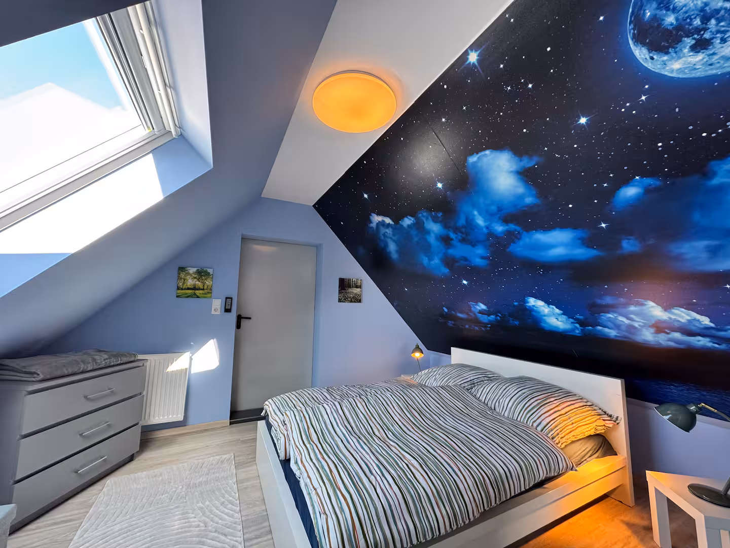 Schlafzimmer mit sternenhimmel fototapete und dachfenster