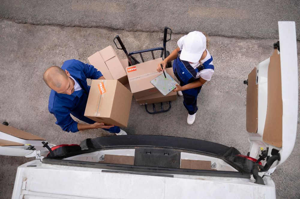 Two movers placing boxes into a truck