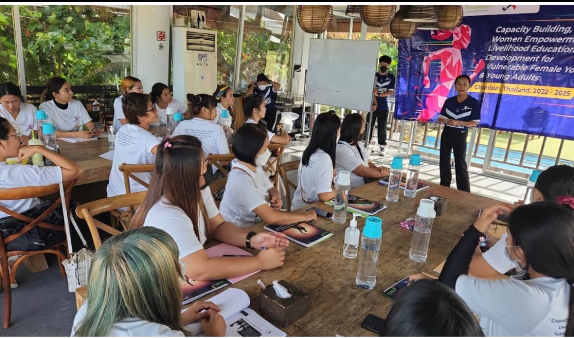 Amara lecturing many female students.