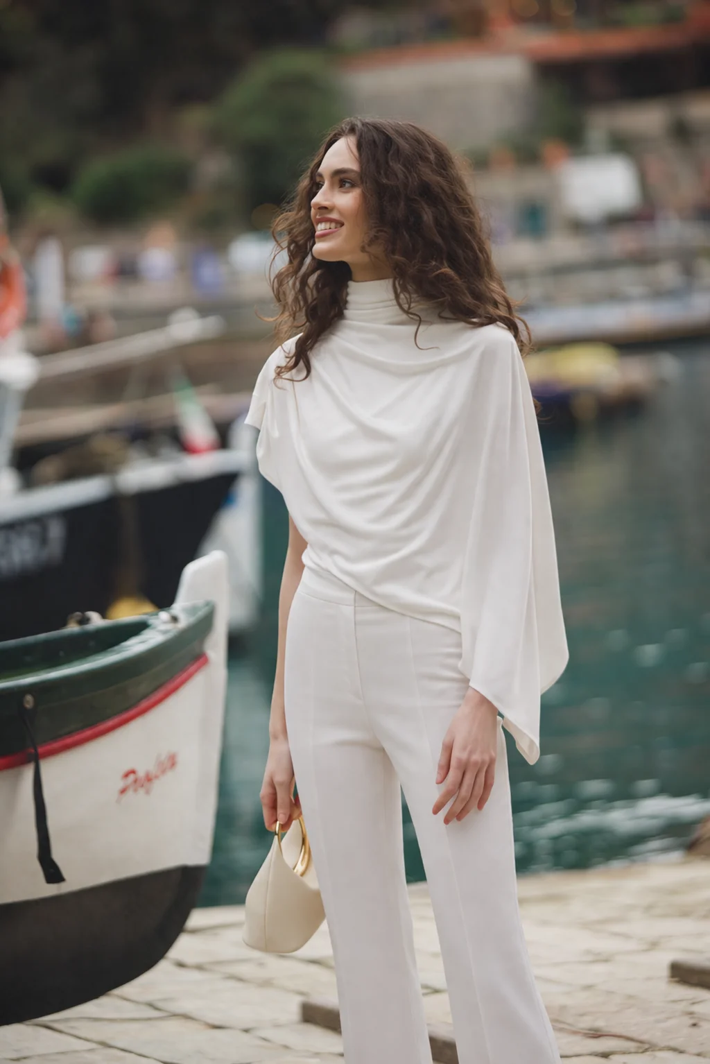 White asymmetric designer top with high neck, integrated cape, and fluid draping 
