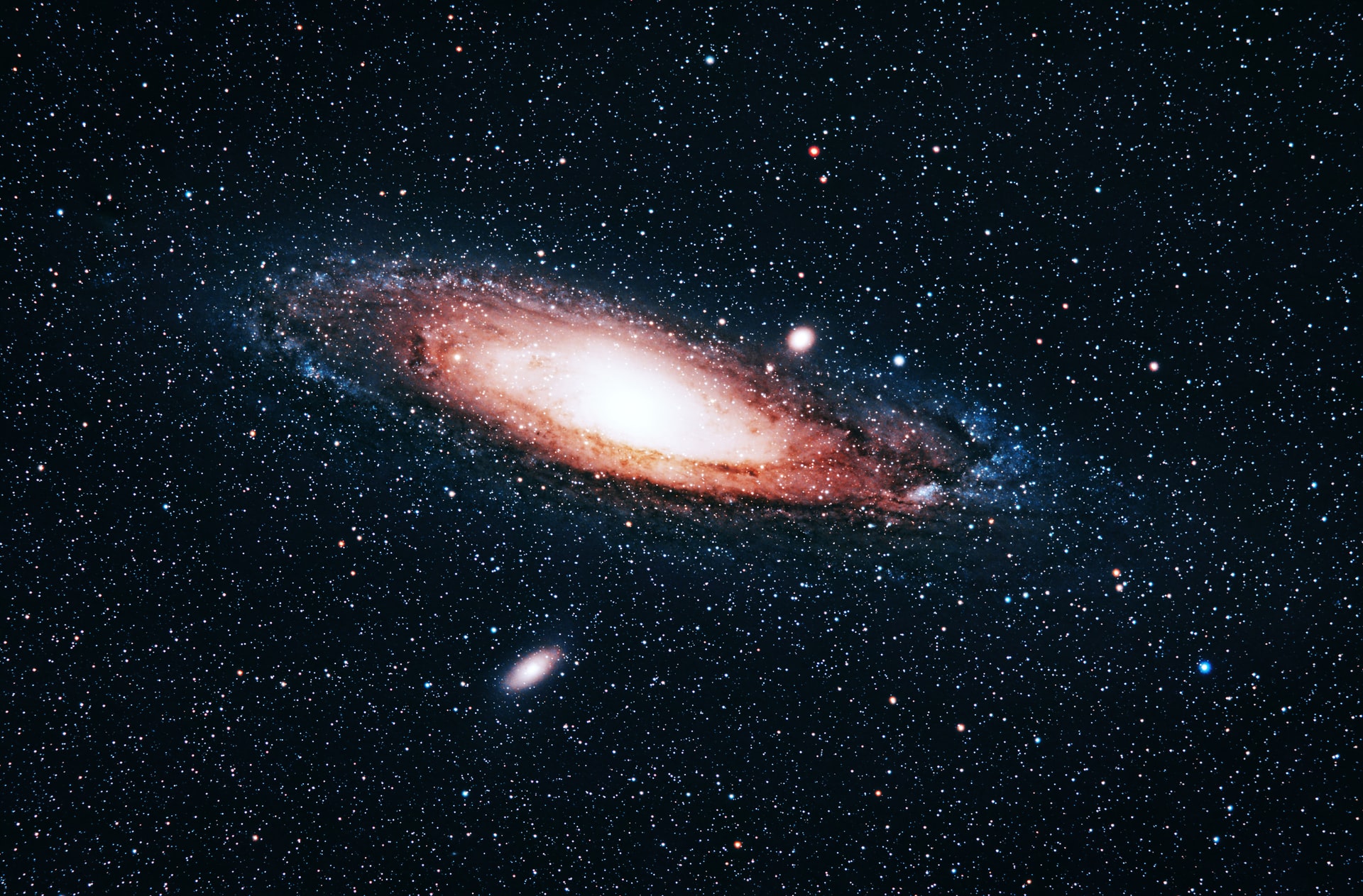 Andromeda galaxy on a dark sky surrounded by thousands of stars sparking the sky.