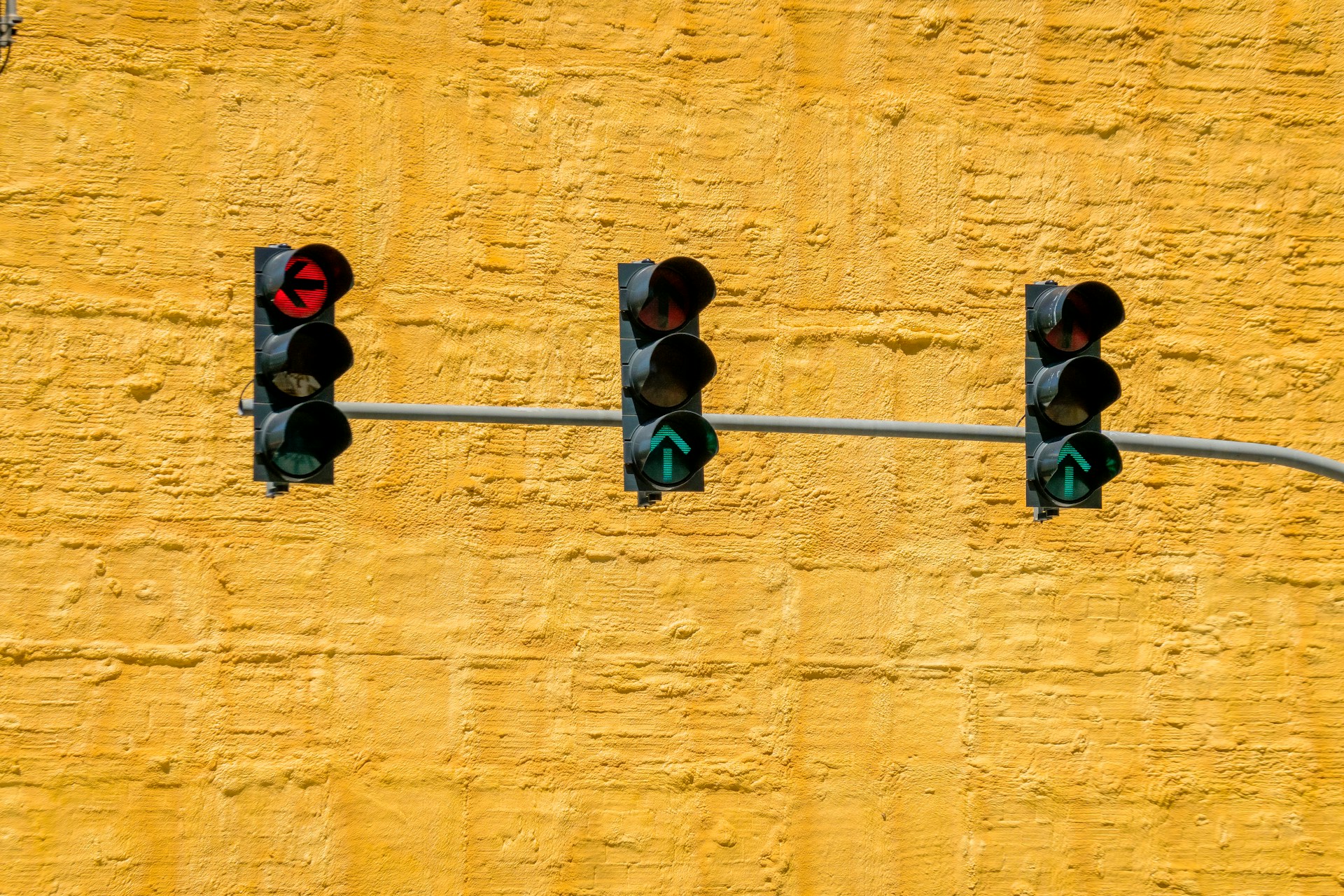 Stop Lights Three stop lights on a yellow textured background. One red with an arrow point left, and 1 green with arrows pointing forward.