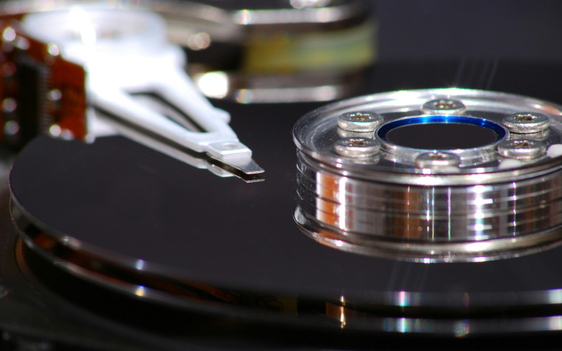 Close up of a hard disk with platters and head exposed.