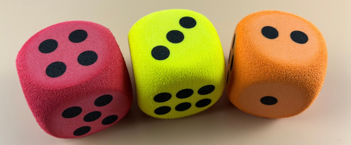 Three brightly colored 6-sided dice