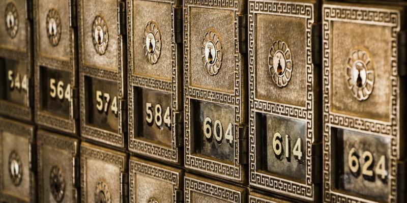 Several rows of small mail boxes with key-based locks that might be found in a postal office or apartment