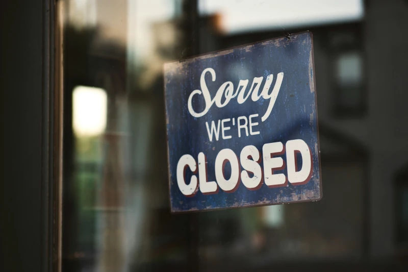 Glass storefront with a sign that reads Sorry we're closed.