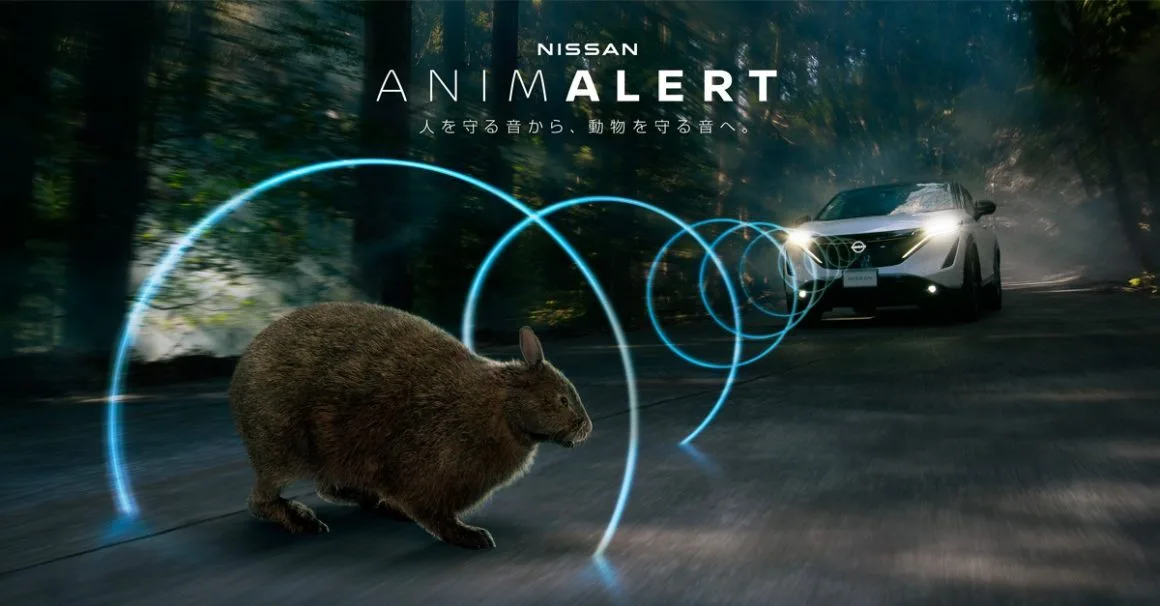 Voiture Nissan équipée de la technologie ANIMALERT circulant sur une route en pleine nature, éloignant un lapin.