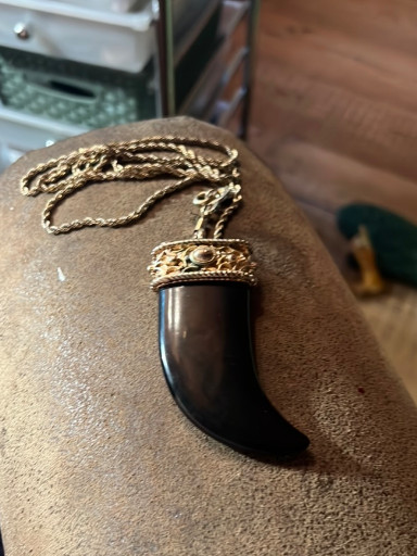 Gold-plated pendant necklace featuring a polished black horn or resin tusk, attributed to Kenneth Jay Lane