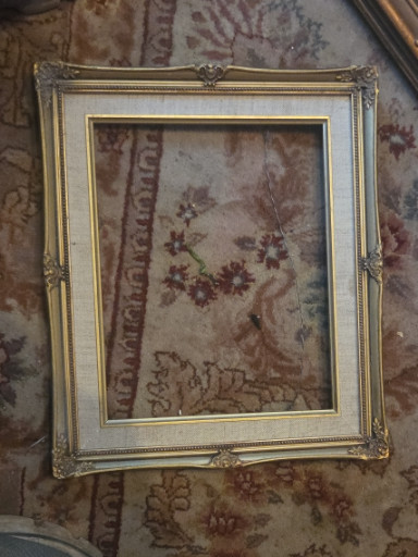 Framed embroidered textile artwork depicting a floral and bird scene in an ornate gilt frame