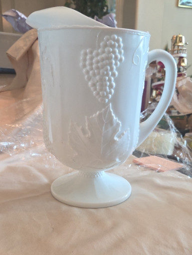Milk glass footed pitcher with embossed grape and leaf pattern by Indiana Glass