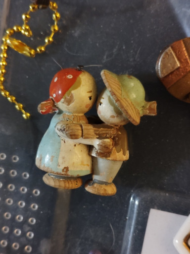 Hand-carved wooden figurine titled 'Boy and Girl Kissing at Fence', likely Anri or similar Italian maker