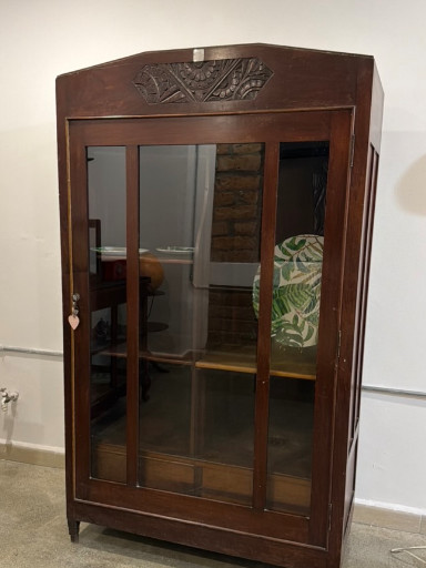 Vitrina de madera tallada con puerta de vidrio, elaborada por el ebanista Delfín Toro