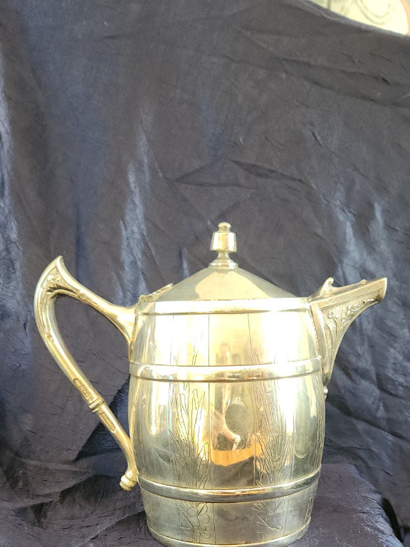 Silver-plated teapot with barrel-shaped body. Manufactured by Reed and Barton. Patented in 1867.