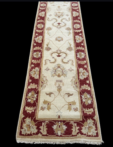 Hand-knotted wool runner rug in traditional Oriental style with ivory field and red border