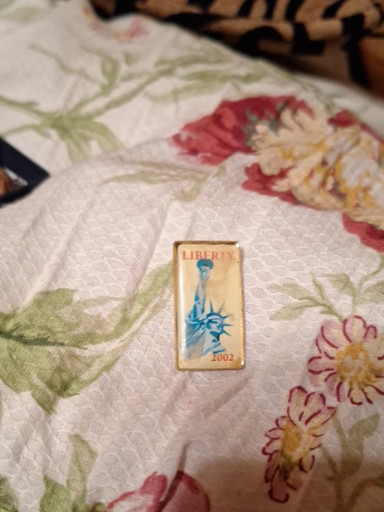 Enamel lapel pin featuring the Statue of Liberty, dated 2002