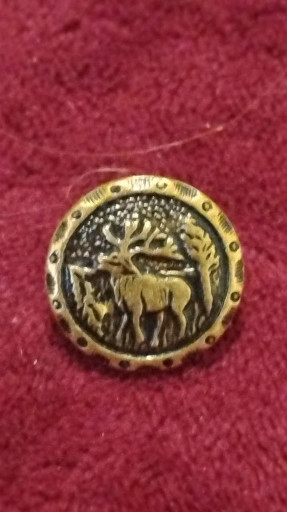 Brass button or pin featuring a stag (elk) with antlers