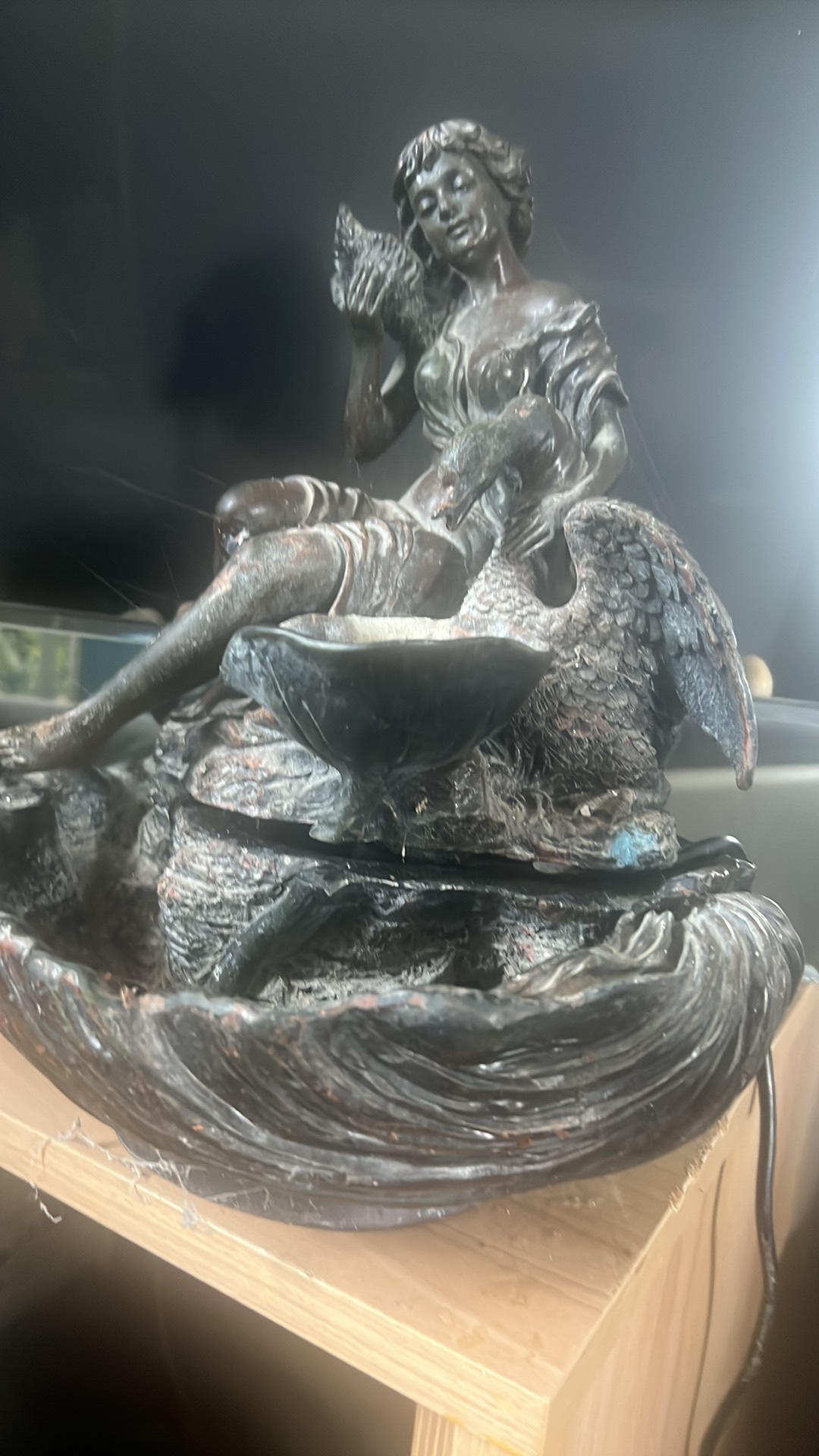 Bronze fountain sculpture of a figure with swan