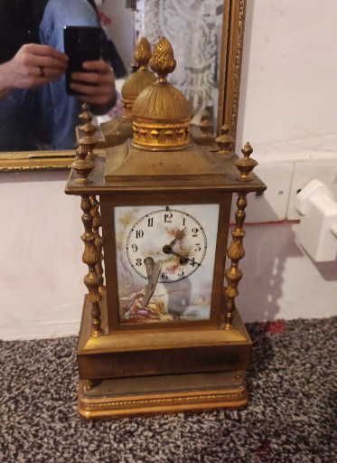Gilt brass French mantel clock with decorative finial and painted enamel dial