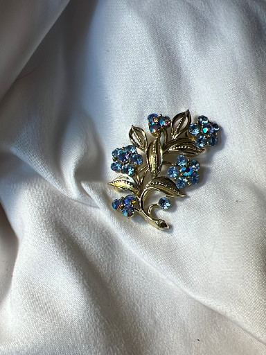Vintage silver-tone floral brooch with blue rhinestones, circa 1950s