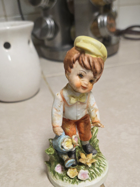 Porcelain figurine of a boy with watering can and flowers