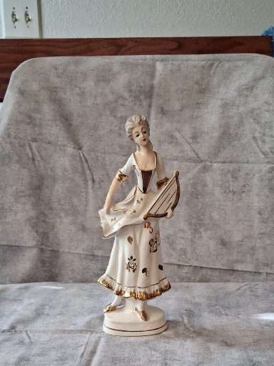 Porcelain figurine depicting an 18th-century lady musician with lyre by Grantcrest