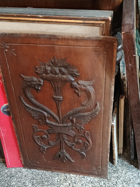 Pannello in legno intagliato con stemma araldico e motivi decorativi