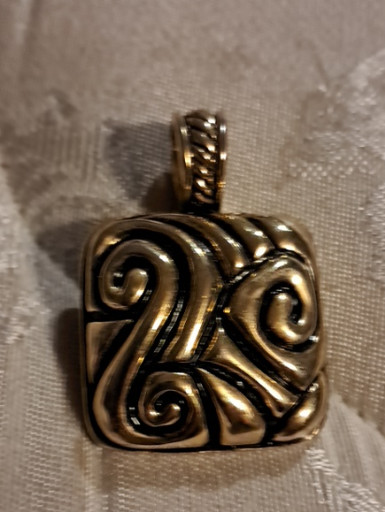 Metal pendant with Celtic-inspired swirl design