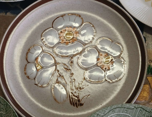 Stoneware dinner plate with embossed floral design, likely by Montgomery Ward or International China