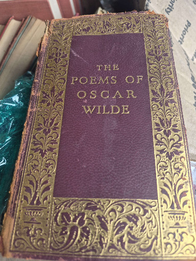 Leather-bound book titled 'The Poems of Oscar Wilde' published by Cosmopolitan Book Corporation