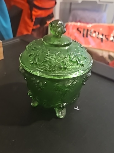 Green pressed glass covered candy dish with grape and leaf pattern by Jeanette Glass Company