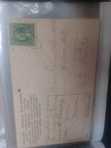 Vintage Christmas postcard featuring an angel with a star and holly