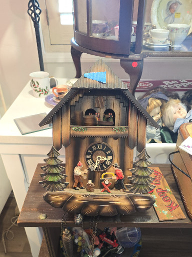 Wooden chalet-style cuckoo clock with animated figurines