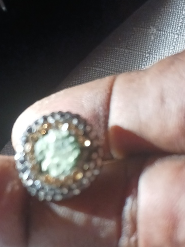 Gold ring with pale green jade or jadeite center stone surrounded by small diamonds or cubic zirconia