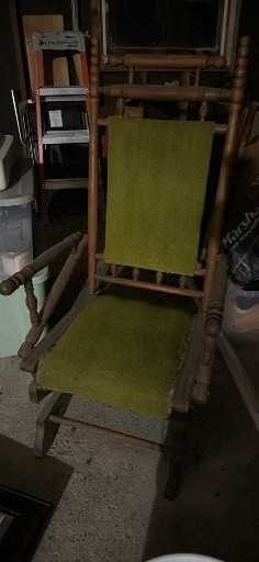 Wooden rocking chair with green upholstered seat and backrest