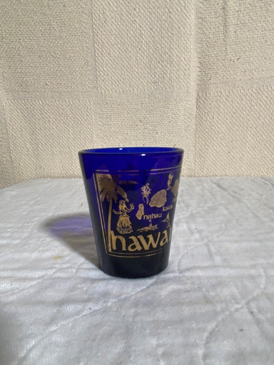Cobalt blue glass souvenir shot glass with gold decoration featuring 'Hawaii' and orchid motifs