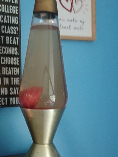 Vintage lava lamp with gold base and red wax, likely by Lava Lite
